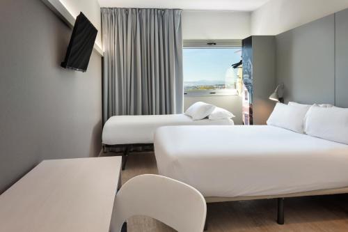 帕特纳B&B HOTEL Valencia Aeropuerto的酒店客房设有两张床和窗户。