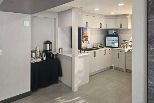 坎卢普斯Rodeway Inn & Suites的厨房配有白色橱柜和黑色台面
