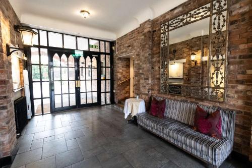 切斯特Crabwall Manor & Spa - BW Signature Collection的带沙发和镜子的客厅