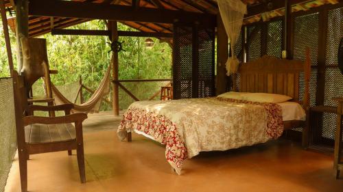 帕拉蒂Cabana do Tarzan na Praia de Parati Mirim的一间卧室配有一张床和一把椅子