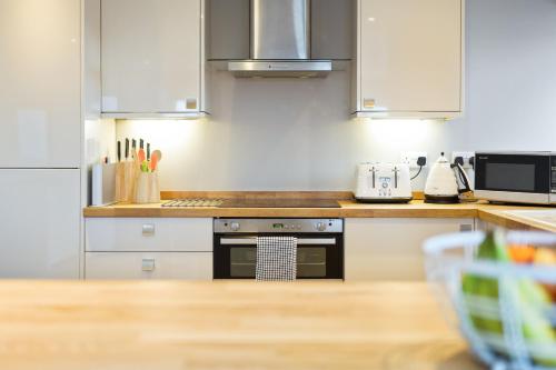 伯恩茅斯Westcliff Penthouse with Sea Views and Balcony的厨房配有白色橱柜和炉灶烤箱。