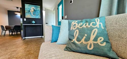 宝藏岩礁Luxury beach villa in paradise.的一张带有枕头的沙发,上面写着海滩生活