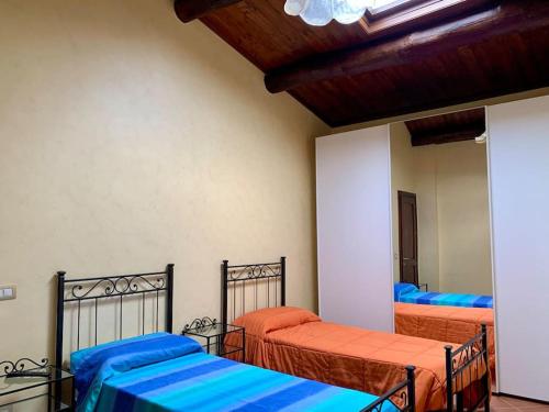 Il Casale - tra Passato e Modernità的一间卧室配有两张蓝色和橙色床单