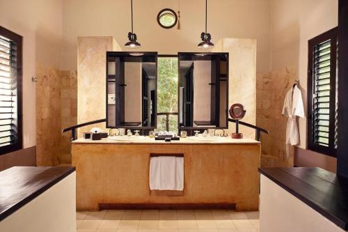 UayamónHacienda Uayamon的一间带两个盥洗盆和大镜子的浴室