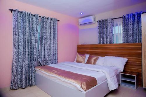 AsiHexagon Hotel的一间卧室配有一张带蓝色窗帘的大床