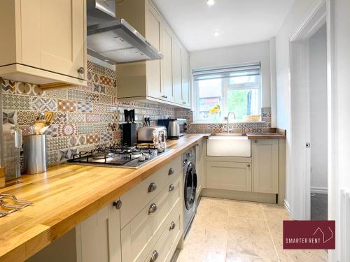 BlackwaterFarnborough - Newly Refurbished 2 Bedroom Home的厨房配有白色橱柜和炉灶烤箱。