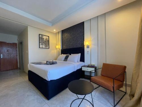 莱基Blue Apple Hotel的酒店客房带一张大床和一把椅子