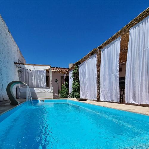 奇莱西托Las catalinas hospedajes的一座房子前面的蓝色海水游泳池