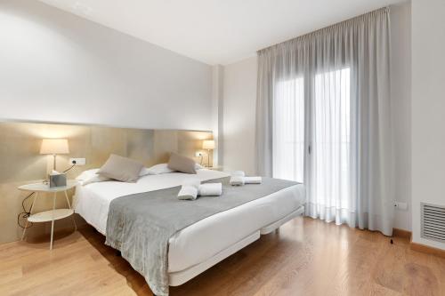 巴塞罗那格拉西亚森萨奥腾公寓的白色的卧室设有一张大床和一个窗户