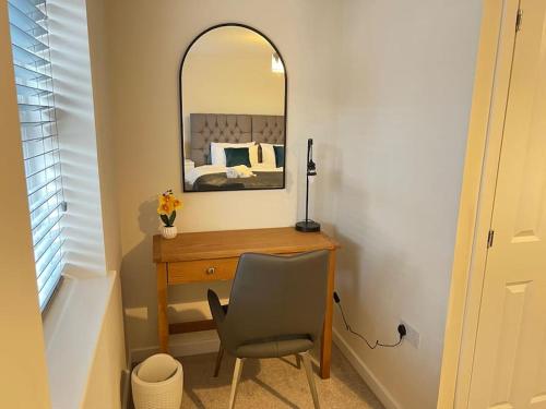 拉夫堡Braid House的一间卧室配有书桌、镜子和椅子