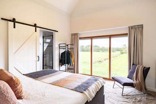 Het Landzicht的一间卧室设有一张大床和一个窗户。