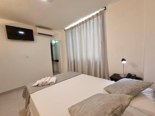 巴兰卡韦梅哈K12 Hotel的一间卧室设有两张床,墙上配有电视。