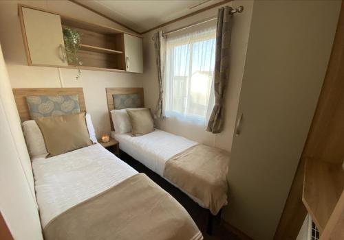 塞尔西Downtime, West Sands, Seal Bay Resort, Selsey的小型客房 - 带2张床和窗户