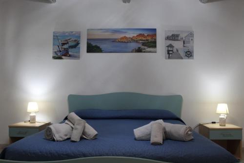 卡拉·利贝罗托viale Marzellinu的卧室配有一张蓝色的床,墙上挂有三张照片