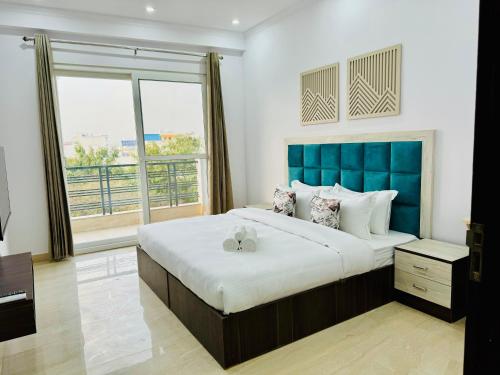 古尔冈ZEN Suites - Golf Course Road Gurgaon的一间卧室配有一张大床和蓝色床头板
