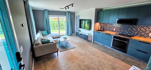 宝藏岩礁Luxury beach villa in paradise.的一间设有蓝色橱柜的厨房和一间客厅
