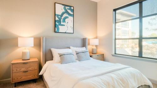 休斯顿Landing Modern Apartment with Amazing Amenities (ID1413)的一间卧室配有一张带两盏灯的床和一扇窗户。