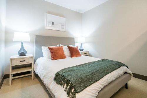 丹佛Landing Modern Apartment with Amazing Amenities (ID1959)的一间卧室配有一张带2个床头柜和2盏灯的床。