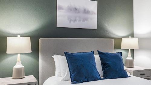 丹佛Landing Modern Apartment with Amazing Amenities (ID1960)的一间卧室配有一张带蓝色枕头的床和两盏灯。