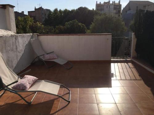 菲格拉斯En el centro de Figueres 4 habitaciones 3 baños y 2 terrazas enormes的两把椅子坐在带围栏的阳台上