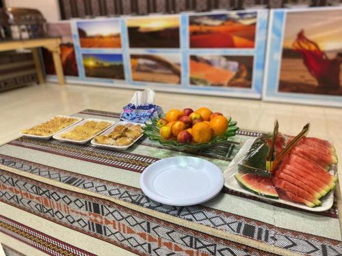 瓦迪拉姆Desert Life Camp的桌上放有水果盘和其他食物