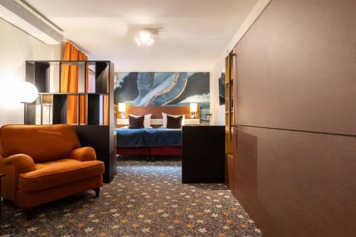哥德堡ProfilHotels Opera的带床和椅子的房间以及一间卧室