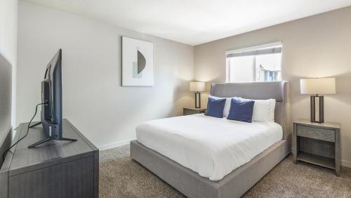温哥华Landing Modern Apartment with Amazing Amenities (ID7205X60)的一间卧室配有一张床和一台平面电视
