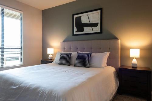 奥斯汀Landing Modern Apartment with Amazing Amenities (ID2977X82)的一间卧室配有一张带两盏灯的大型白色床。