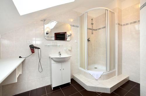 捷克克鲁姆洛夫HOTEL RAJSKY的带淋浴和盥洗盆的白色浴室