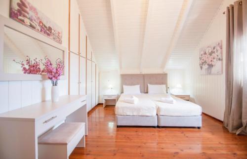 扎金索斯镇Zante Sun I - Getaway Villa!的白色卧室配有一张床,墙上挂着鲜花