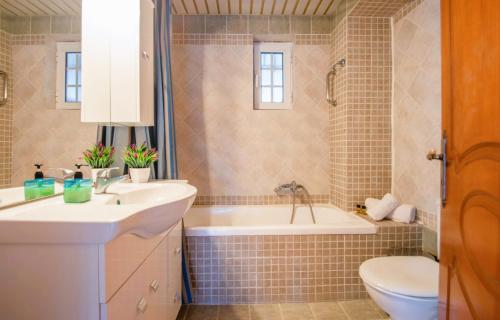 扎金索斯镇Zante Sun I - Getaway Villa!的一间带水槽、浴缸和卫生间的浴室