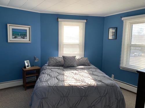 布拉德利比奇Bradley Beach Cozy Retreat的一间蓝色卧室,配有床和2个窗户