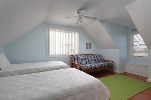 希塞德高地Island Time- beautifully renovated bay view home的一间卧室配有一张床、一张沙发和吊扇。