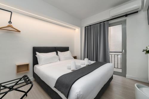 雅典Hotel Adonis Athens的卧室配有一张大白色床和窗户