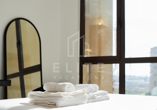 迪拜Madinat Jumeirah Living 1 Bed Pool and Garden View的一堆毛巾,放在窗前的柜台上