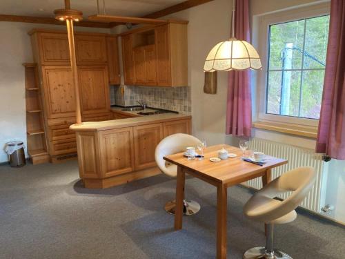 巴德艾森卡珀尔Motel Brunner Apartments & Zimmer的厨房配有桌子、两把椅子、一张桌子和一个窗户。