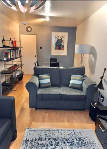 伦敦Entire 2 bedroom house in Hackney的客厅配有蓝色的沙发和桌子