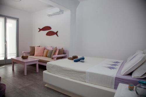 洛加拉斯Paros Melodia Apartments的一间卧室配有一张大床和一张沙发