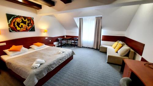 卡尔帕奇Malachit Karpacz SPA Hotel的酒店客房,配有床和沙发