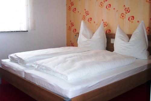 KottmarsdorfFerienwohnung Kottmarsdorf的一张带白色床单和枕头的床