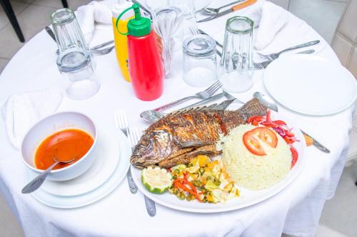 内罗毕Epitome Times Hotel的一张带一盘鱼和一碗汤的白色桌子