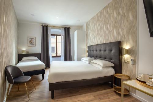 罗马Amalia Suites by Remember Rome的酒店客房,配有两张床和椅子