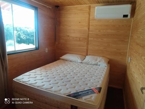 巴热Casa Container Amarela的一个小房间的小床,设有窗户