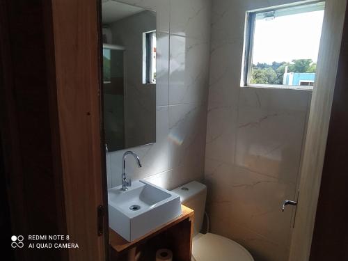 巴热Casa Container Amarela的一间带水槽和卫生间的浴室以及窗户。