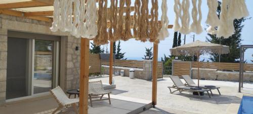 卡拉米锡Zephyros Villas - Agios Nikitas的庭院配有桌椅和吊灯。