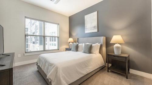 富兰克林Landing Modern Apartment with Amazing Amenities (ID7741X92)的一间卧室配有一张带两盏灯的床和一扇窗户。