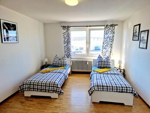 Neckarau2 bedrooms appartement with balcony and wifi at Neckarau Mannheim的带窗户的客房内设有两张单人床。