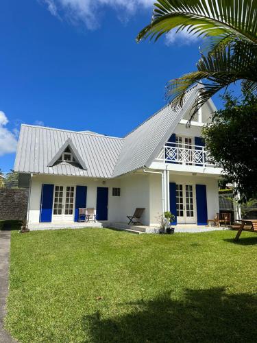 勒唐蓬Villa Nicky的白色的房子,有蓝色的门和棕榈树