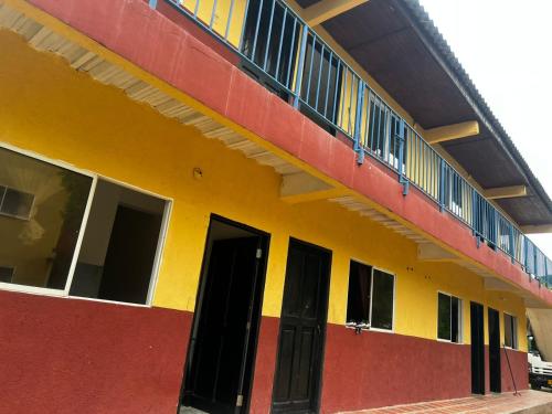 科韦尼亚斯Apartamentos Coveñas的黄色和红色的建筑,设有阳台