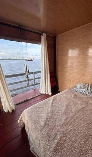 马瑙斯Flutuante Long Beach Manaus Am的一间卧室配有一张床,享有水景